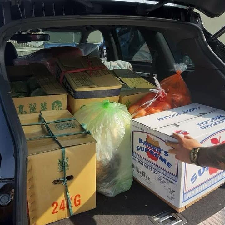 後車廂滿載準備送出的蔬果與物資箱