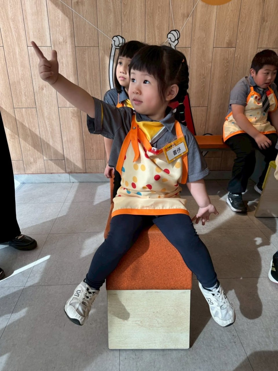 戴著點點圍裙的孩子舉手回答問題