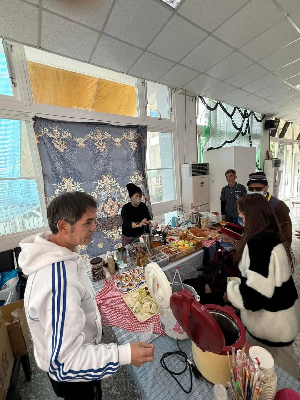 志工在活動中心準備餐點與飲品招待長輩